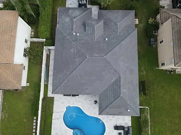 Top-down aerial of a home with a grey tile roof and pool