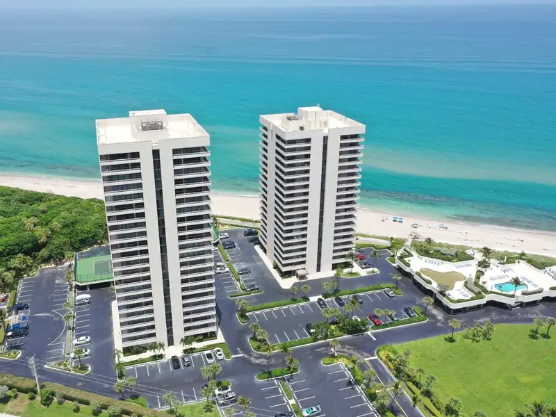 Two oceanfront residential towers with new flat roofs, water behind