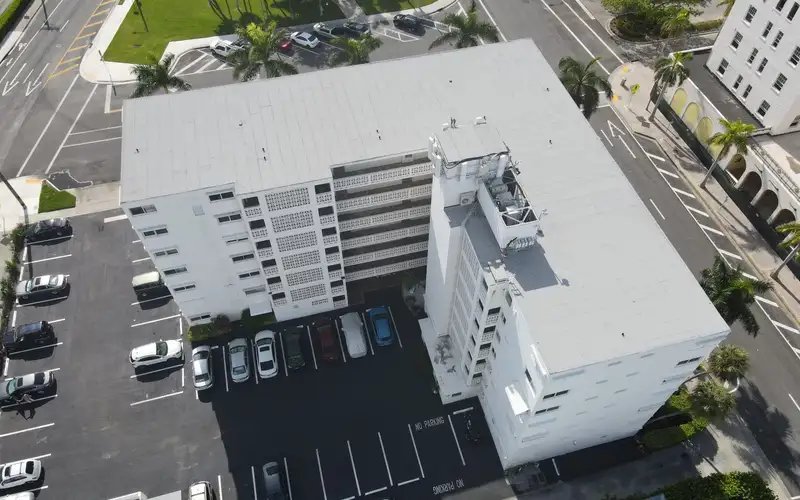 New white flat roof on a mid-rise building, seen by drone