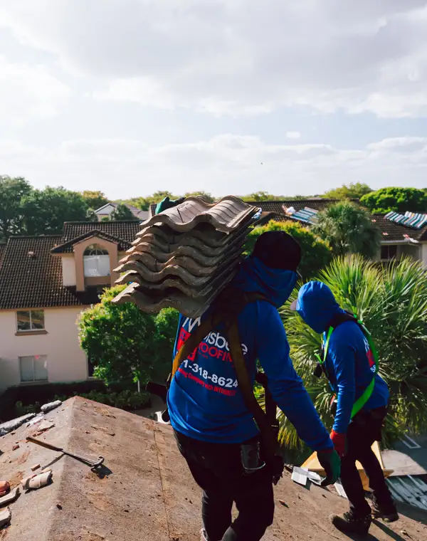 A Molsbee roofer carrying a stack of roof tiles on his shoulder