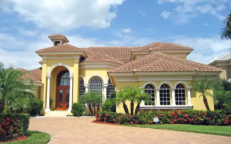 Mediterranean estate with a new barrel tile roof and paver drive